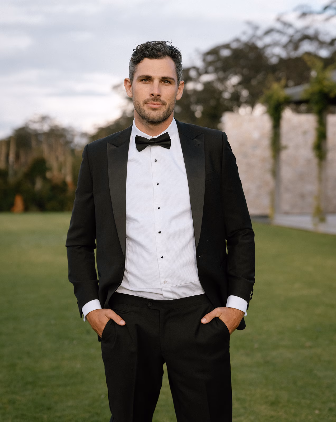 Man in tuxedo in garden by Black Jacket Suiting in Brisbane
