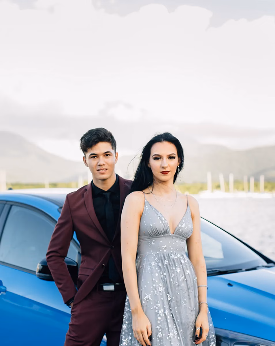 Couple in Suit and dress in front of blue car